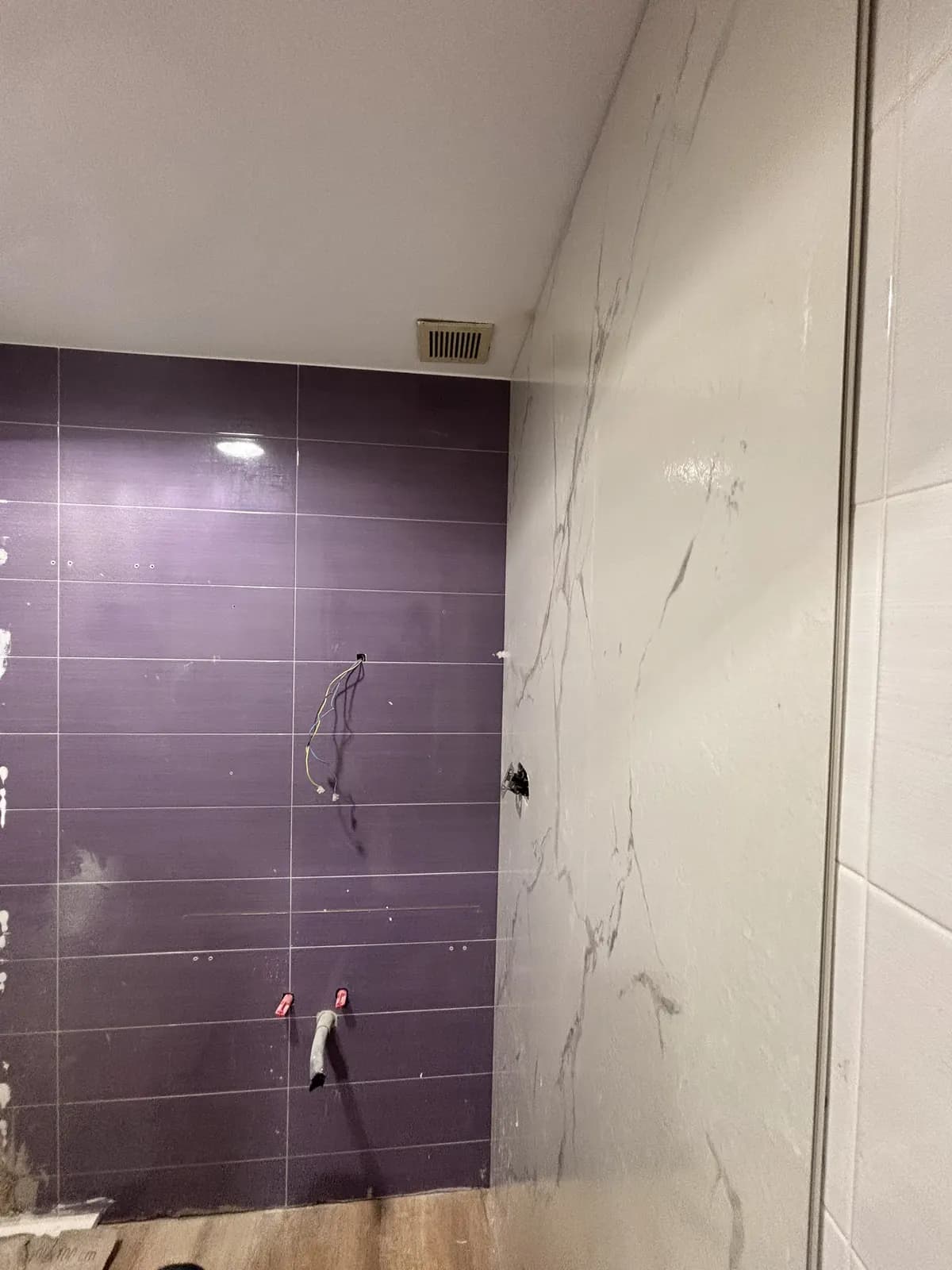 Instalación de acabados de pared avanzando alrededor de la ducha