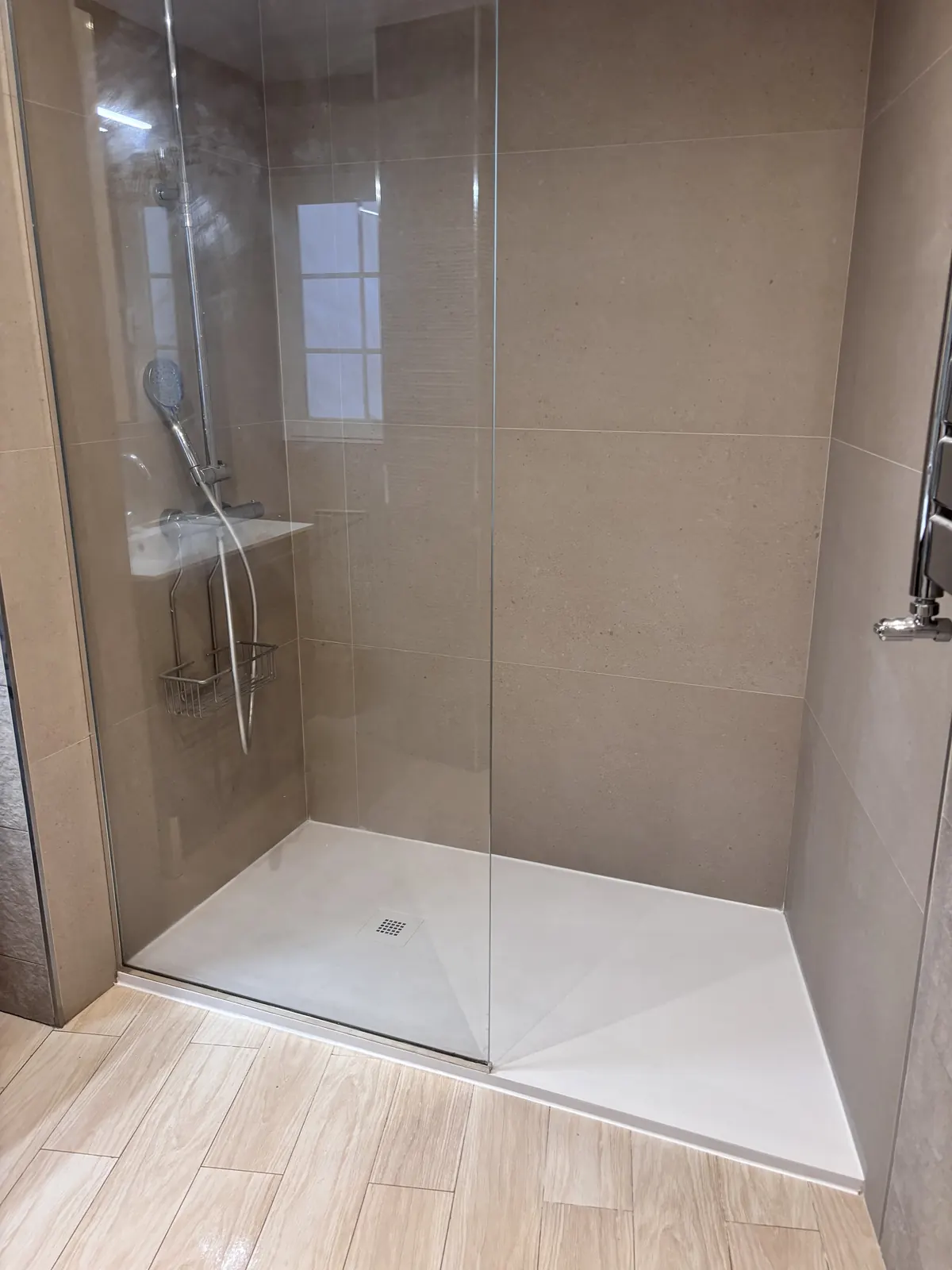 Resultado final de ducha moderna integrada en la distribución del baño