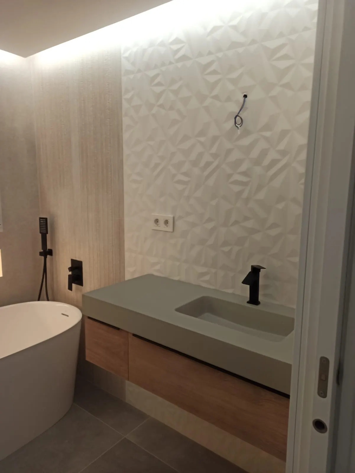 Detalle del lavabo suspendido y revestimiento decorativo